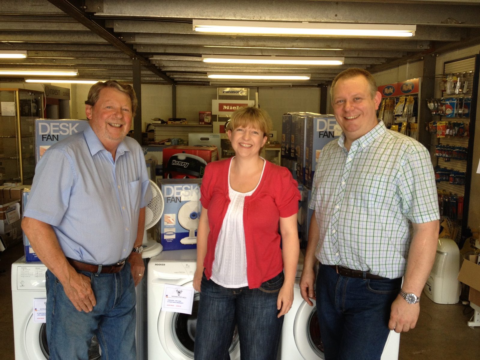 The Phoenix Electrical team in the showroom, in front of washing machines and desk fans